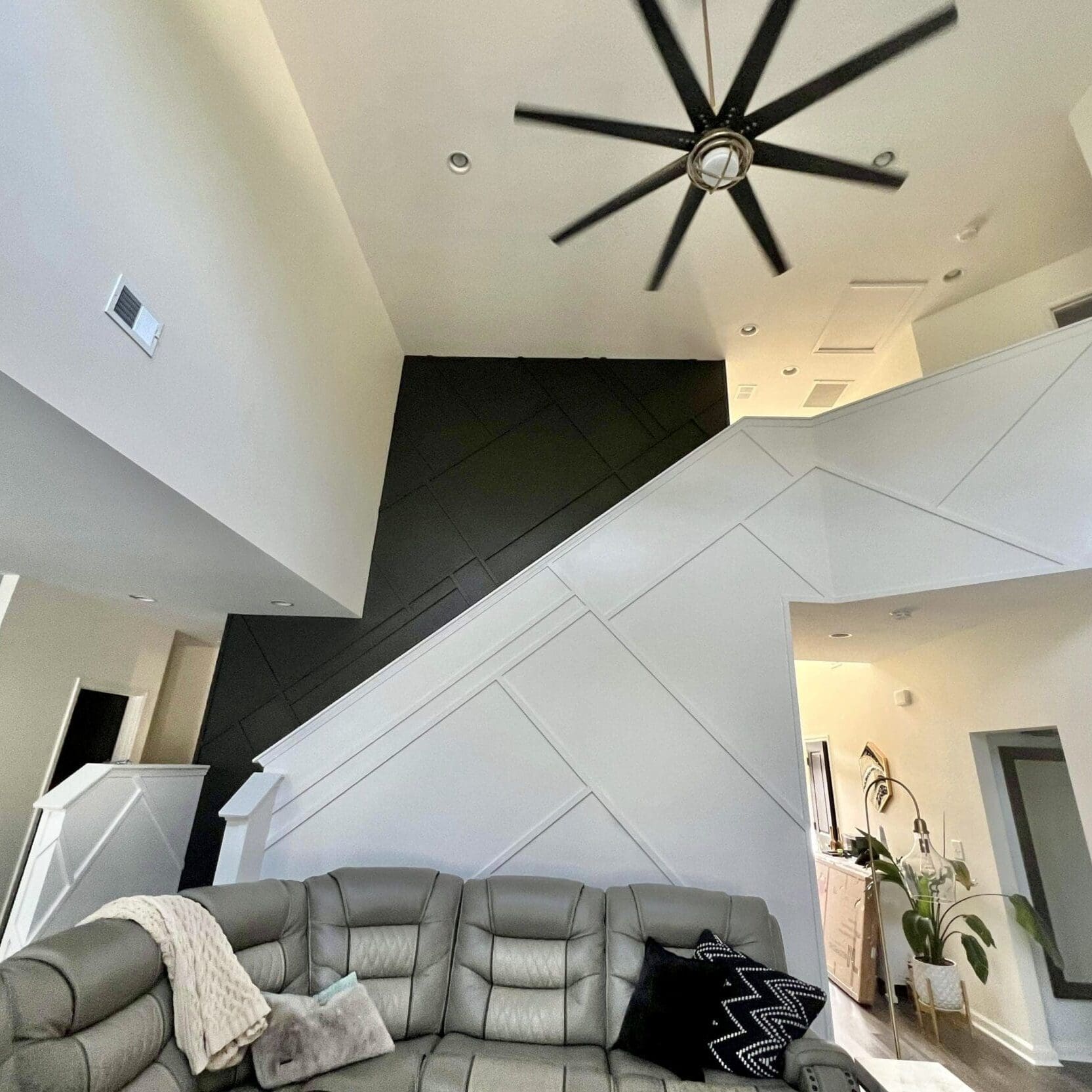 room with modern staircase and ceiling fan